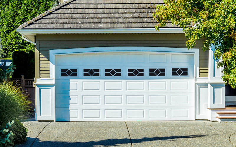White Short Raised Panel steel Garage Door material with Waterton Windows on a Craftsman Style Home